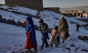Члены перемещенной семьи идут за водой в пригороде Кабула, Афганистан.
