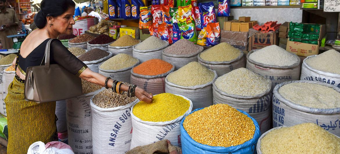 Uma mulher seleciona grãos em um mercado no centro de Karachi, no Paquistão.