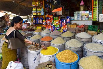 Uma mulher seleciona grãos em um mercado no centro de Karachi, no Paquistão.