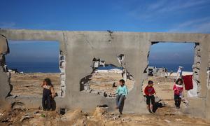 Children gather at a destroyed building in Al Nuseirat, in central Gaza.