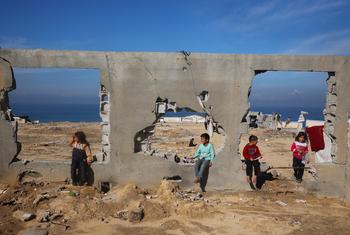Children gather at a destroyed building in Al Nuseirat, in central Gaza.