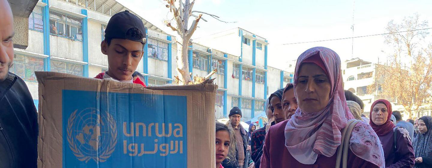Des personnes reçoivent une aide humanitaire de l'UNRWA à Gaza.