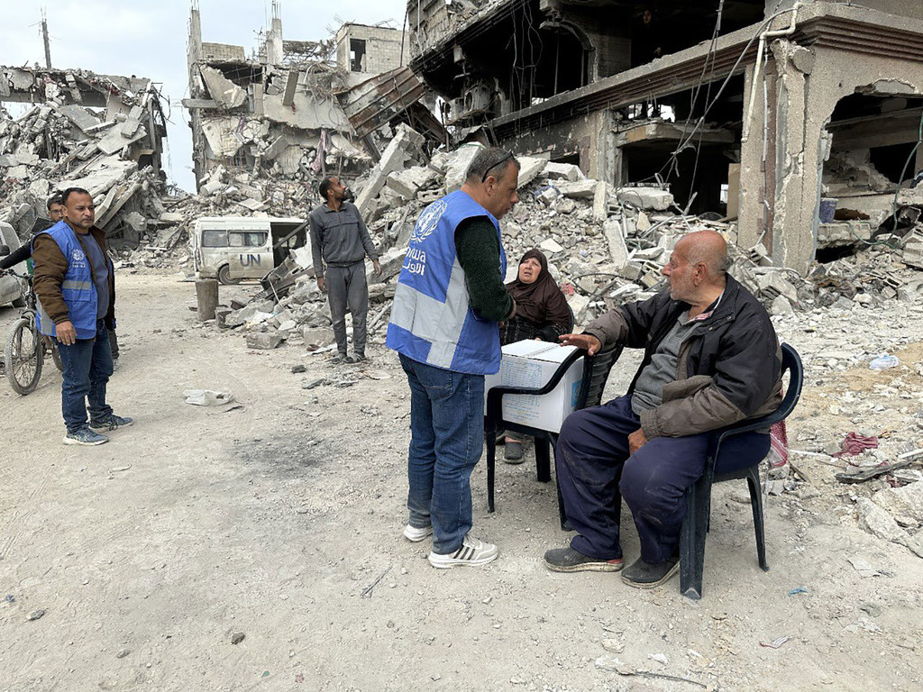 Wafanyakazi wa UNRWA watoa msaada kwa familia iliyopoteza makazi yao katikati ya vifusi vya majengo yaliyoharibiwa huko Gaza.