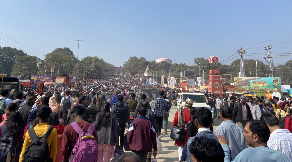 महाकुंभ मेले के दौरान गंगा नदी की ओर जाती हुई लोगों की एक विशाल भीड़।