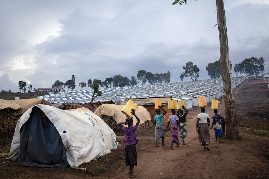 Des femmes portent de l'eau vers un camp de déplacés en RDC
