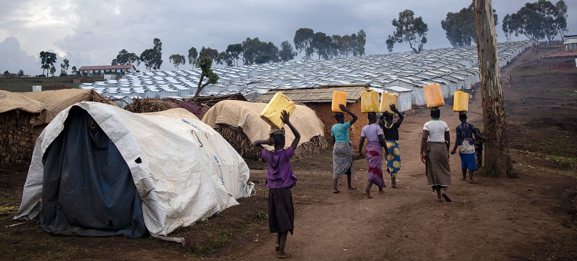 Des femmes portent de l'eau vers un camp de déplacés en RDC