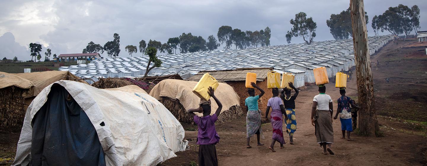 Des femmes portent de l'eau vers un camp de déplacés en RDC.