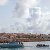 Un bateau en bois transportant 13 réfugiés et migrants de Tunisie et du Maroc est remorqué dans le port de Lampedusa en octobre 2020.
