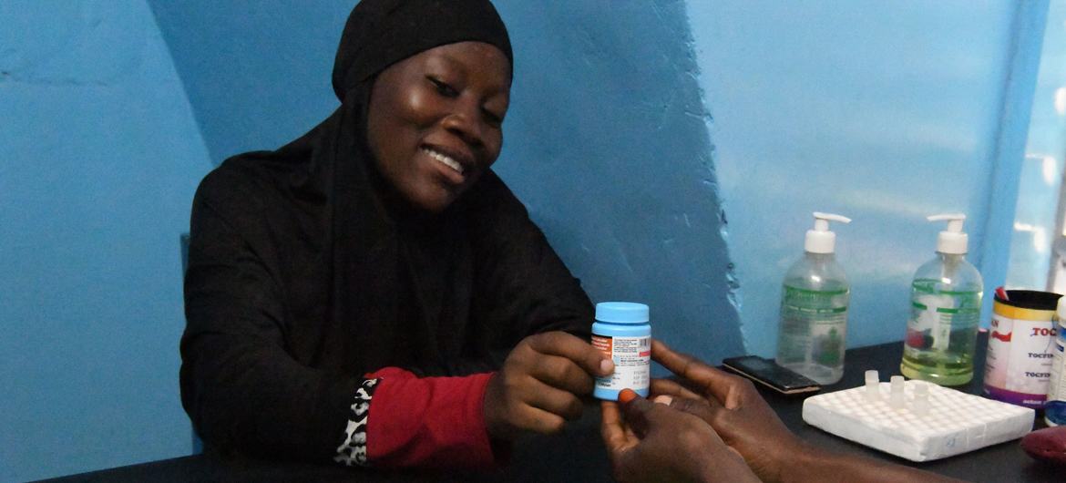Mulher nascida com HIV recebe medicação de uma clínica em Burkina Faso