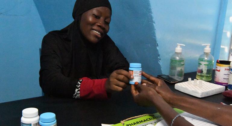 Mulher nascida com HIV recebe medicação de uma clínica em Burkina Faso
