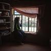 Une femme de 31 ans est assise près de la fenêtre. Elle était cheffe d'entreprise avant la prise de pouvoir par les Talibans.