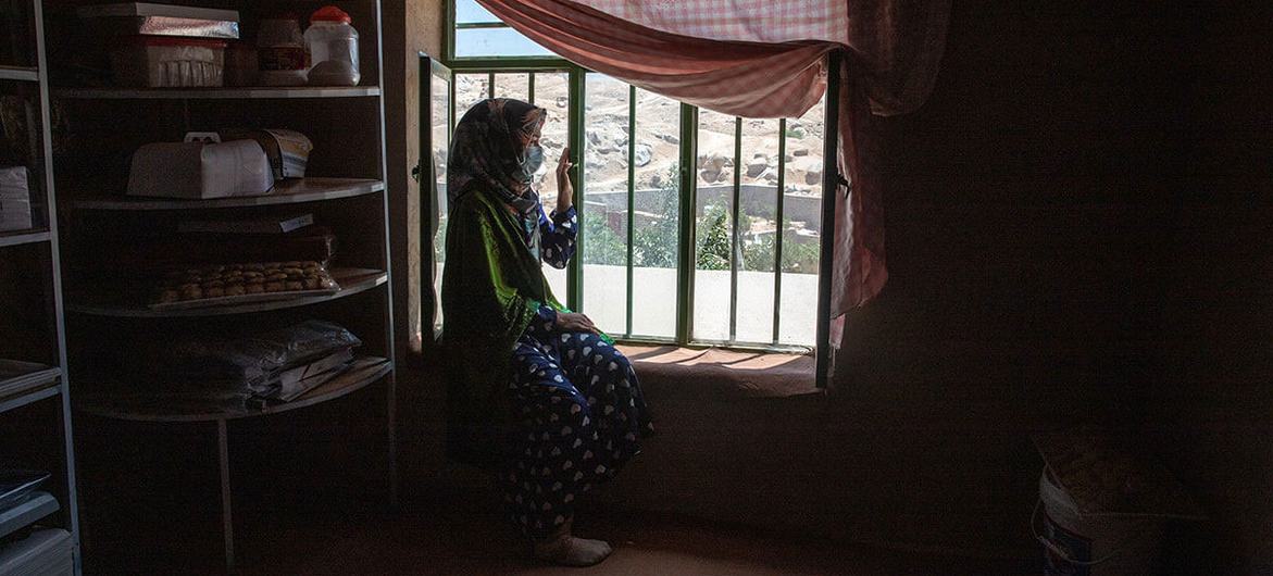 A 31-year-old woman sits by the window. She used to be an entrepreneur before the Taliban takeover.