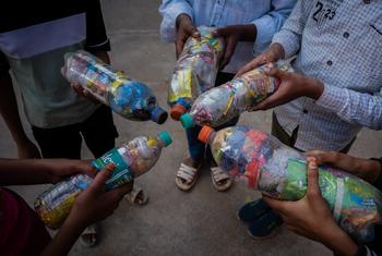 UNICEF की एक पहल के तहत भारत में बच्चे रीसाइक्लिंग के लिए कचरे से भरी प्लास्टिक की बोतलें पकड़े हुए हैं।