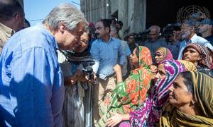 यूएन महासचिव एंतोनियो गुटेरेश, पाकिस्तान के बाढ़ प्रभावित सिन्ध और बलूचिस्तान प्रान्तों में, प्रभावितों से उनका हाल-चाल पूछते हुए (सितम्बर 2022).