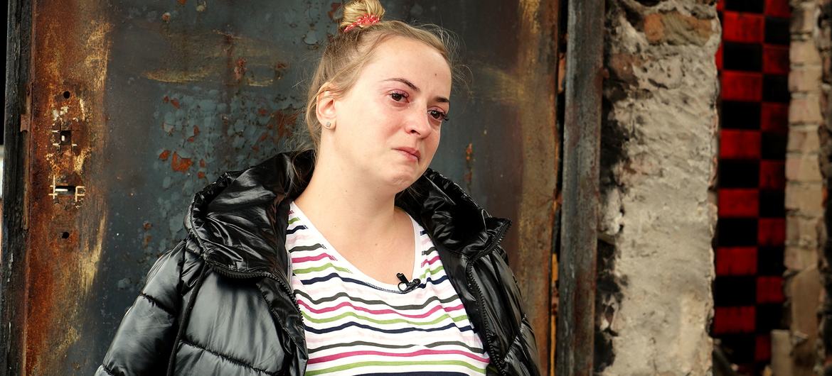 Mulher senta-se do lado de fora do que resta de sua casa, depois que ela foi destruída durante um bombardeio pesado em Kyiv, na Ucrânia