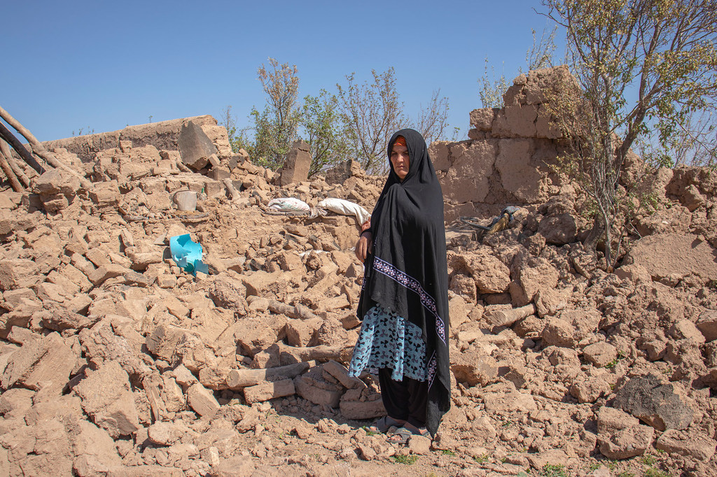 Une femme se tient dans les décombres de sa maison détruite dans la province de Herat, en Afghanistan.