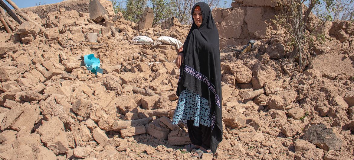 A woman stands in the rubble of her destroyed home in Herat Province, Afghanistan.