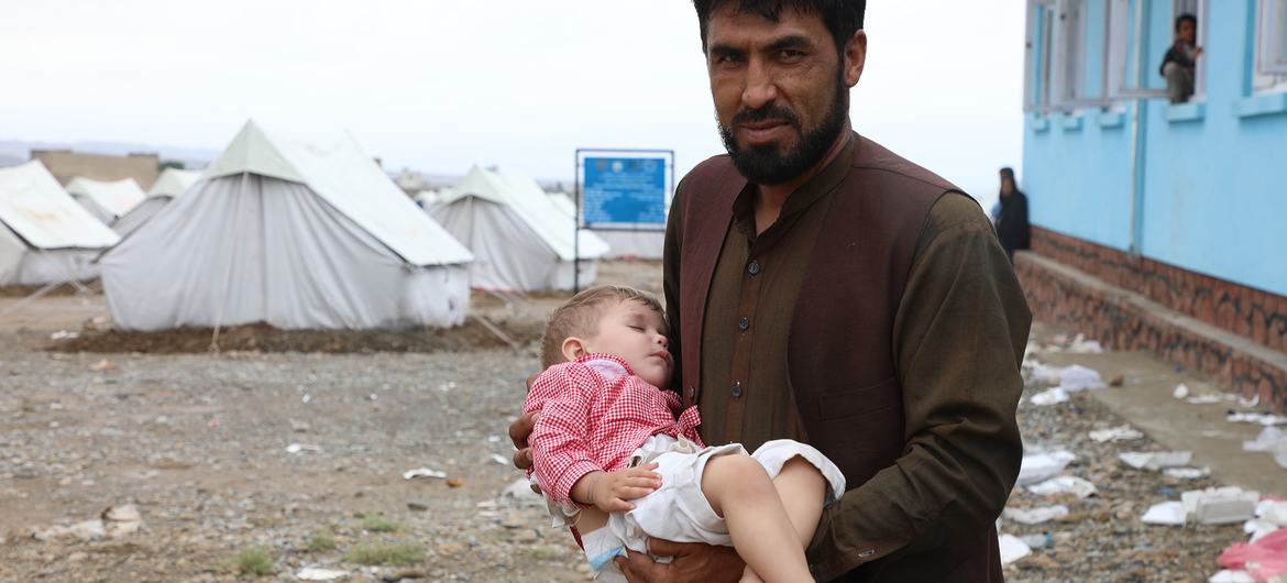 A father brings his child to a UNICEF-supported mobile health clinic to seek treatment in Logar Province, Afghanistan, where his home has been destroyed by recent floods.