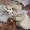इण्डोनेशिया के जयापुरा में एक स्वास्थ्यकर्मी महिला के रक्त में शुगर की जाँच करते हुए. 