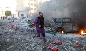A first responder rushes through the aftermath of shelling that targeted hospitals and displaced camps in Idlib, northwest Syria (file).