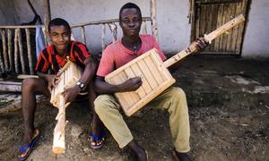 Young men play their hand-crafted musical instruments in a refugee camp in Borkeza, Liberia, in 1987. (file)