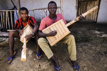 Young men play their hand-crafted musical instruments in a refugee camp in Borkeza, Liberia, in 1987. (file)
