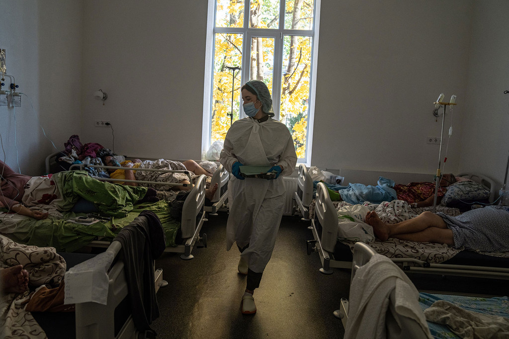 Un trabajador sanitario con equipo de protección camina por una sala de hospitales en Kramatorsk, Ucrania, donde los pacientes están hospitalizados por COVID-19.