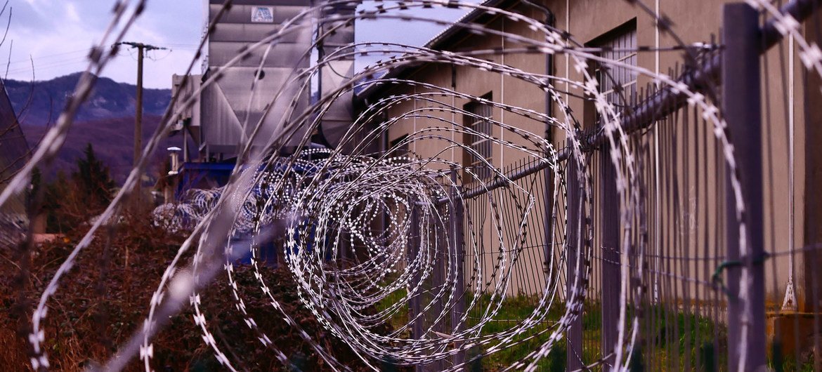 Barbed wire fencing surrounds a detention centre.
