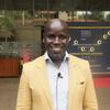 Dkt. Ronex Tendo kutoka Uganda akitabasamu katika hafla ya chakula cha jioni cha shukrani cha Pointi Nne na Sheraton.