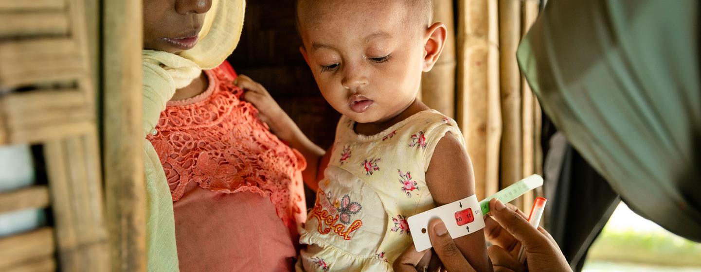 Un bénévole évalue l’état nutritionnel d’un enfant dans un camp de réfugiés de Cox’s Bazar, au Bangladesh.