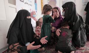 A nutrition counsellor advises a mother and her children in a village in the central region of Afghanistan in June 2022.