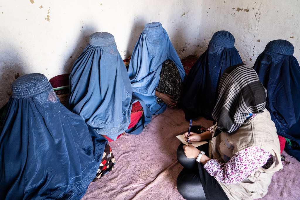 联合国人道协调厅的一名女工作人员在同阿富汗东部的几名流离失所妇女交谈。