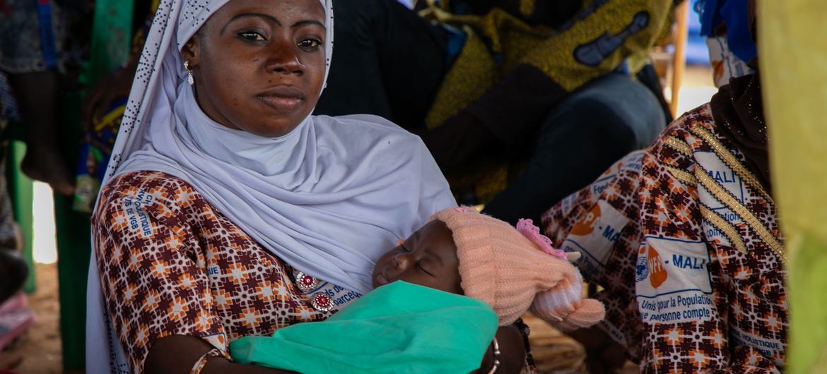 Una mujer con su bebé escucha al personal del UNFPA en una sesión de sensibilización sobre violencia de género en el One Stop Centre del hospital de Sominé Dolo.