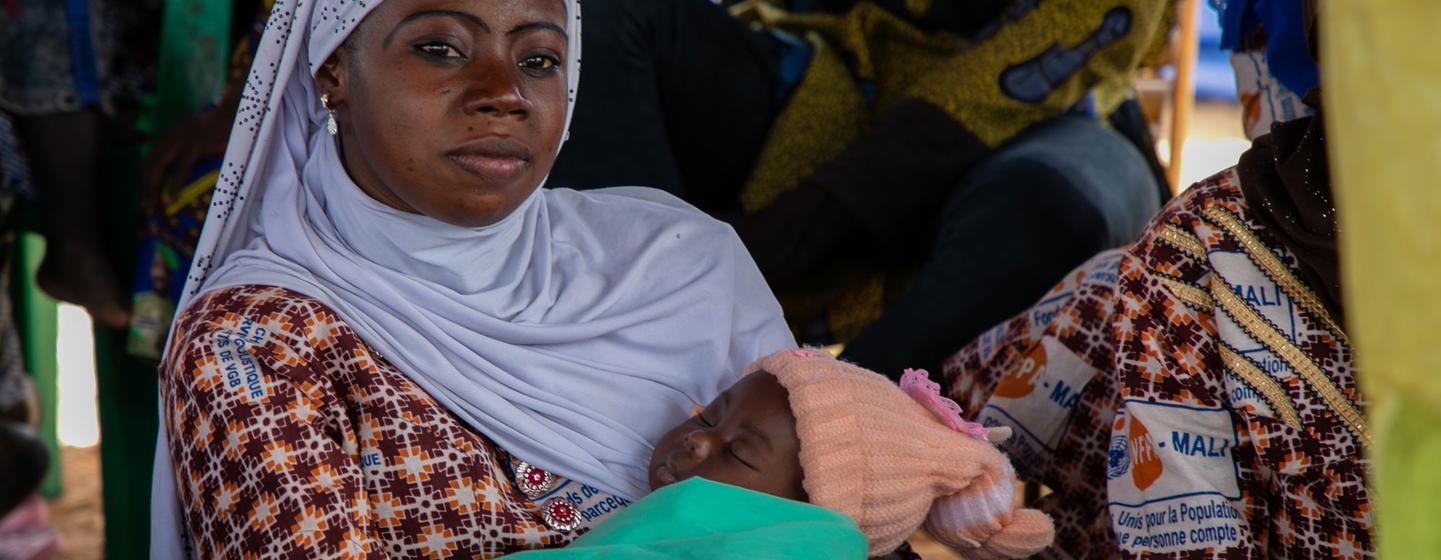 Une femme avec son bébé écoute le personnel de l'UNFPA lors d'une session de sensibilisation sur la violence basée sur le genre au One Stop Centre de l'hôpital Sominé Dolo.