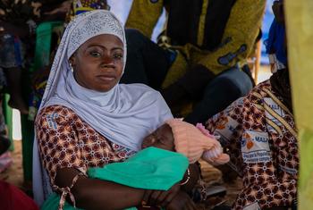 Una mujer con su bebé escucha al personal del UNFPA en una sesión de sensibilización sobre violencia de género en el One Stop Centre del hospital de Sominé Dolo.
