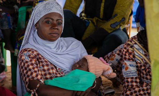 Uma mulher com seu bebê ouve a equipe do UNFPA em uma sessão de conscientização sobre violência de gênero no One Stop Centre do Hospital Sominé Dolo.