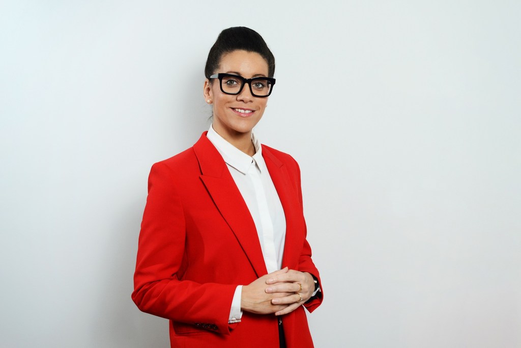 Portrait of Minna Epps, Head of the Ocean Program at the International Union for the Conservation of Nature (IUCN), in a red blazer and white shirt against a light grey background.