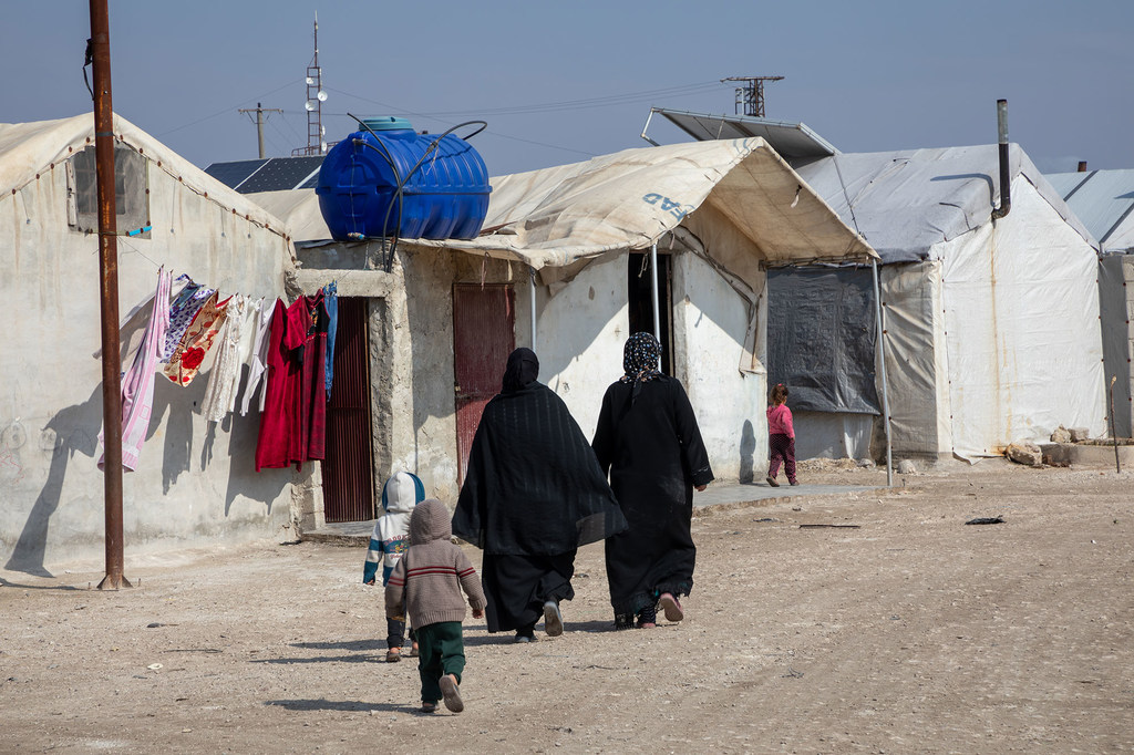 Watu wakipita mbele ya makazi ya wakimbizi ya Al-Muhammadiyah karibu na Jendires, kaskazini magharibi mwa Syria.
