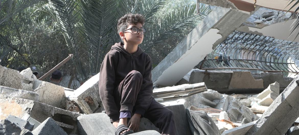 طفل فلسطيني يجلس فوق منزله المدمر في غزة نتيجة القصف الجوي الإسرائيلي.