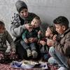 A Palestinian family  in Gaza share a meal bought with a WFP food voucher.