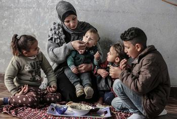 Une famille palestinienne de Gaza partage un repas acheté avec un bon alimentaire du PAM.