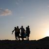 Picha za wanaume wanne zilizopambwa kwa mtindo wa "silhouettes" zikiwa zimebeba mwili kwenye begi katika mandhari ya jangwa wakati wa machweo huko Obock, Djibouti.