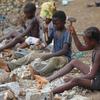 Children working in a rock quarry in Sierra Leone, breaking large pieces of granite into gravel.