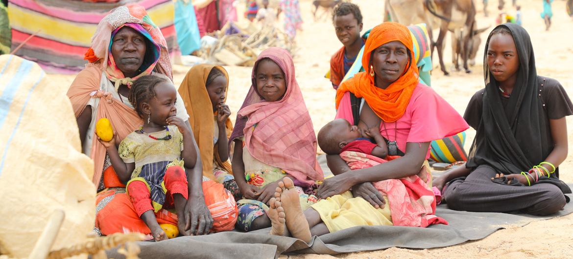 Une famille soudanaise s'abrite à un point d'entrée des réfugiés près de la frontière tchadienne avec le Soudan.