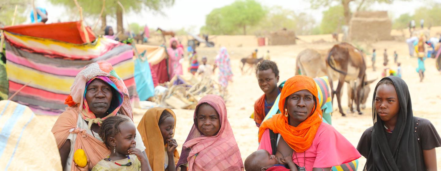 Une famille soudanaise s'abrite à un point d'entrée des réfugiés près de la frontière tchadienne avec le Soudan.