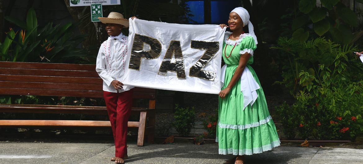 来自哥伦比亚太平洋沿岸的青年领袖们高举写有 "和平 "的西班牙文标牌。