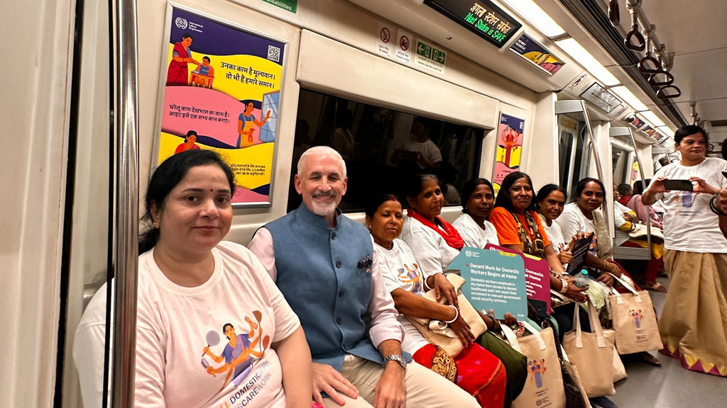 घरेलू कामगारों के अधिकारों के बारे में जागरूकता अभियान के लिए ILO की प्रतिनिधि शोम्बी शार्प और घरेलू कामगारों और समुदाय के सदस्यों का एक समूह दिल्ली मेट्रो ट्रेन में सवार है।