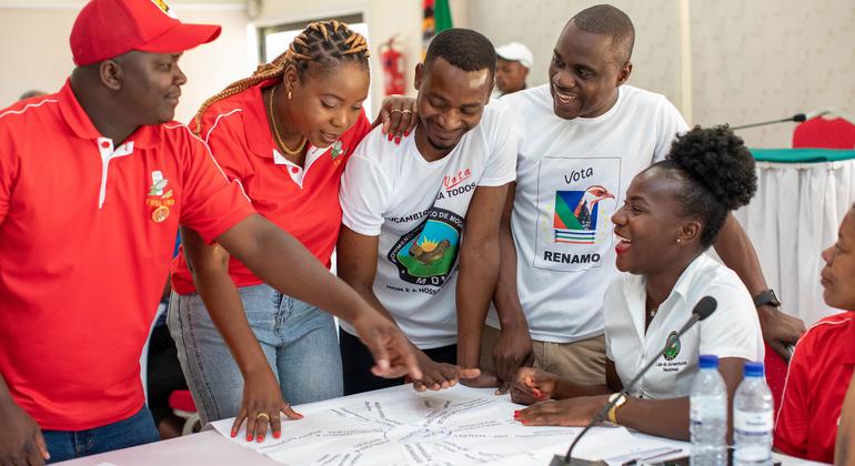 Um grupo de jovens membros de partidos políticos moçambicanos, incluindo dois da FRELIMO e dois da RENAMO, reúnem-se em torno de uma mesa para discutir um plano em conjunto.