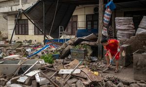 A young Vietnamese man cleans up debris at his home after Typhoon Yagi swept through Quang Ninh province.