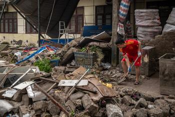 A young Vietnamese man cleans up debris at his home after Typhoon Yagi swept through Quang Ninh province.